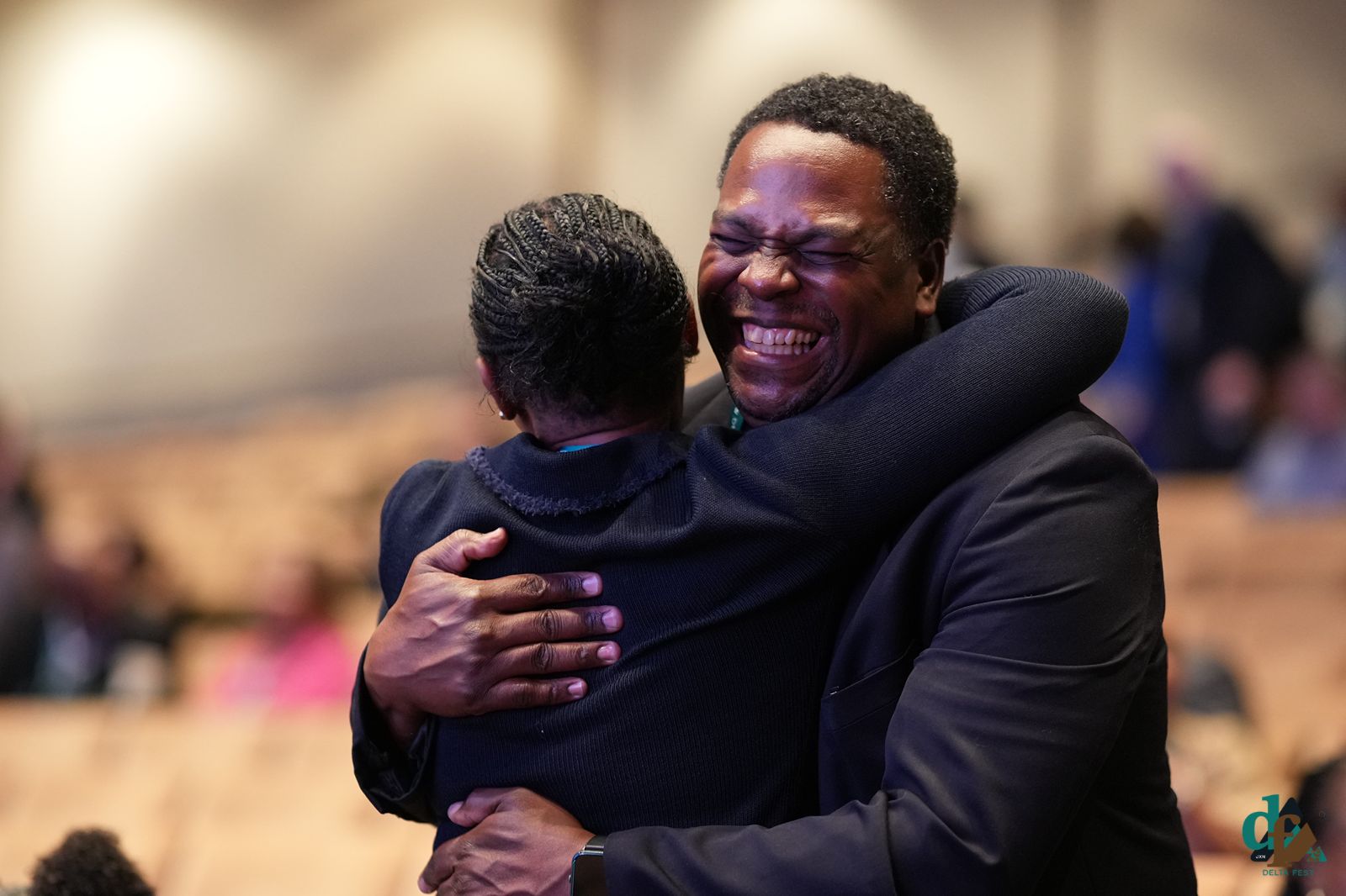 Two attendees embrace, laughing, at DELTA FEST 2026