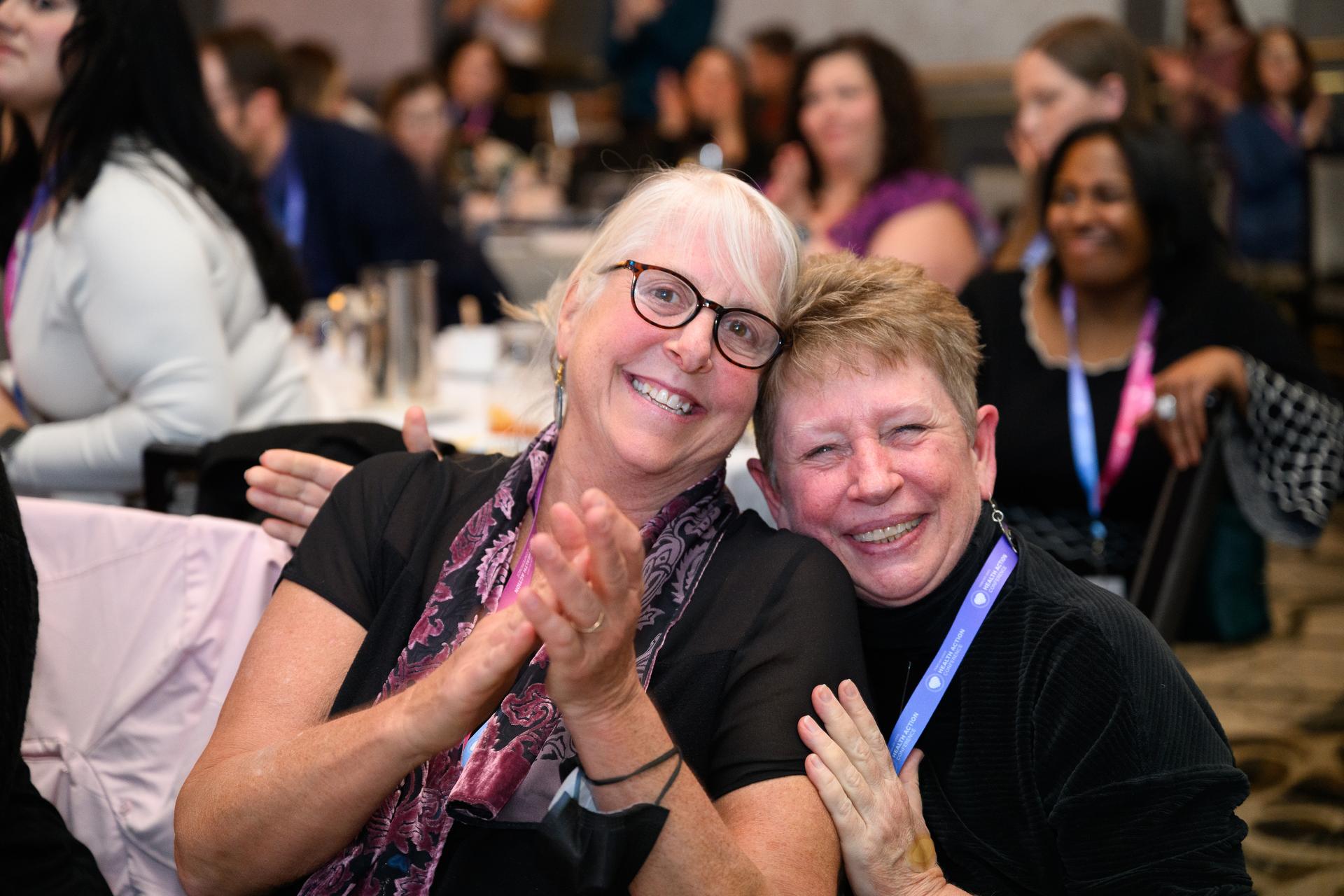 Attendees hugging and posing